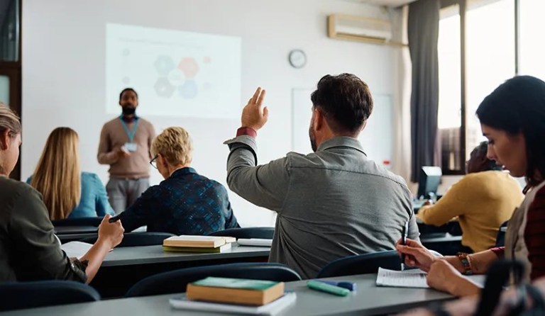 Student raising hand in a classroom